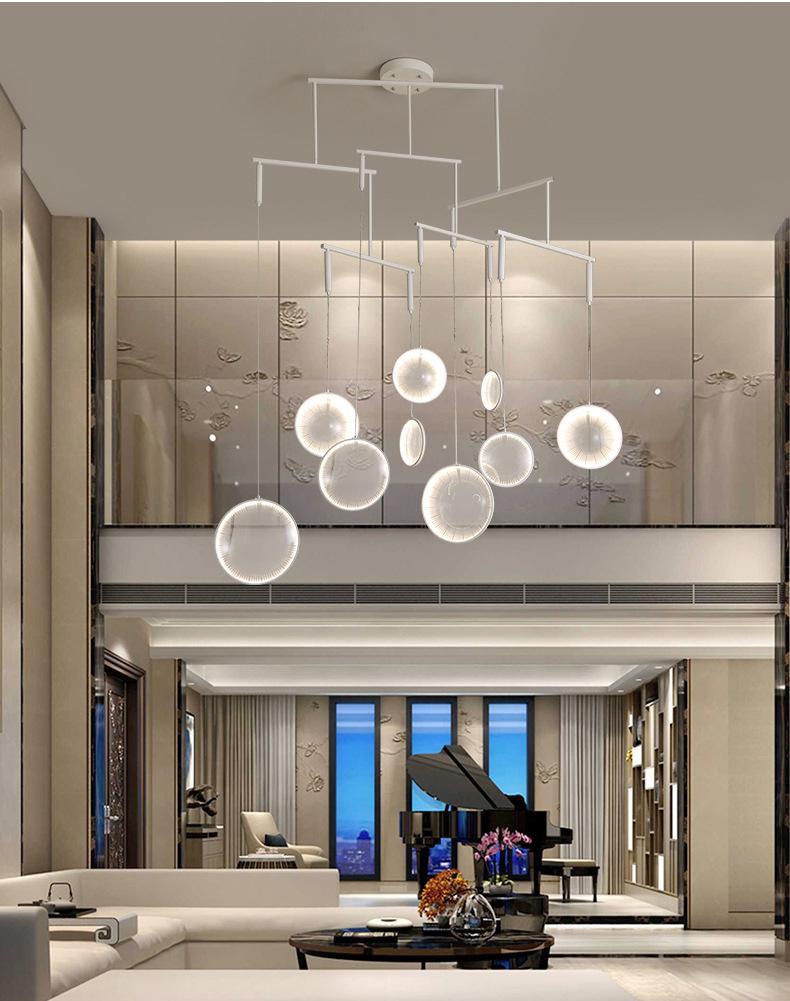 LED Lens Chandelier with nine illuminated discs in a luxurious double-height living room